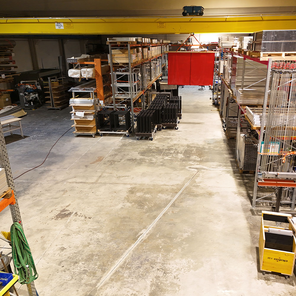 Produktionshalle bei ferry solutions mit Aluminiumteilen, Regalen und mobilen Werkstationen